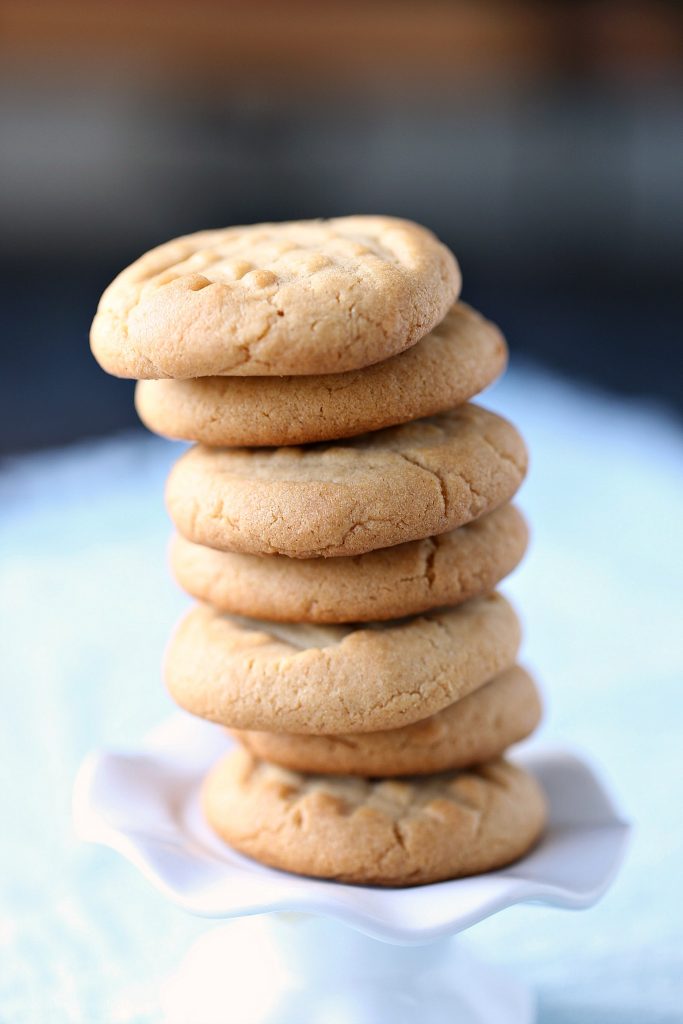 peanut butter cookies stacked on a white stand