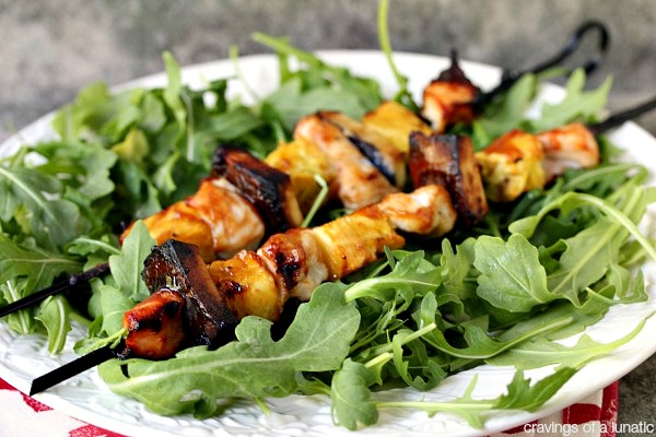 Fruity Chicken Kebabs served on a bed of arugula on a white plate