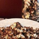 Chocolate Cake Popcorn in a white bowl with a mason jar full of popcorn in the background