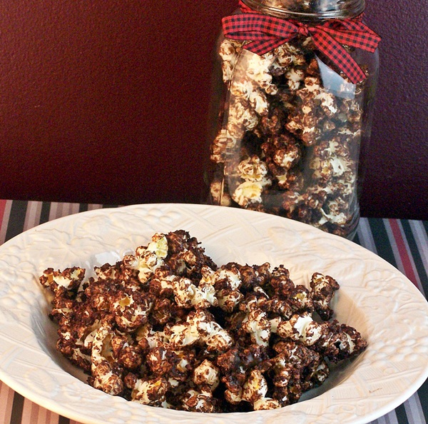 Chocolate Cake Popcorn served in a white bowl with a mason jar full of popcorn in the background