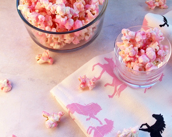 Old Fashioned Pink Popcorn served in small glass bowls on a white towel with pink and black horses on it