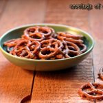 taco seasoned pretzels cooked in a slow cooker placed in a green bowl on a table for snacking