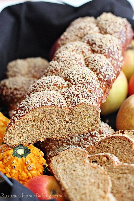 Whole Wheat Pumpkin Challah served in a towel lined basket with apples and mini pumpkins