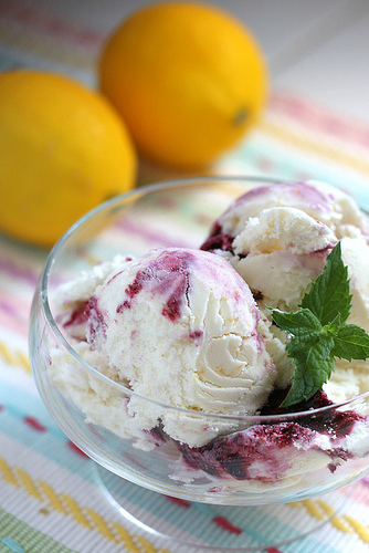 Blackberry Lemonade Ice Cream served in a glass bowl with lemons in background