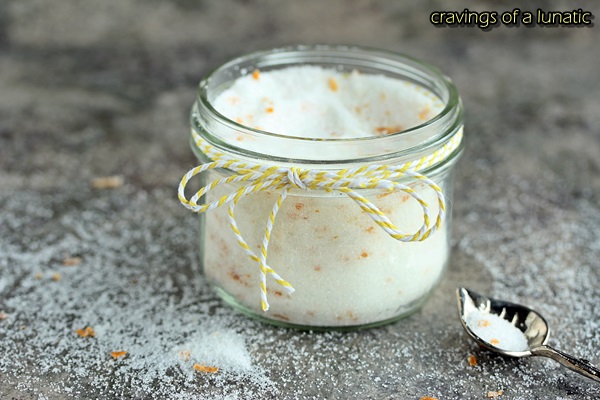 Meyer Lemon Sugar stored in a mason jar with a spoon sitting on the counter