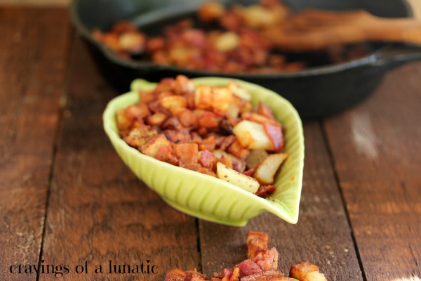 Potato and Bacon Breakfast Hash cooked in a cast iron pan and served in a green bowl