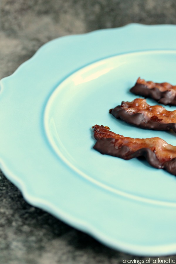 3 slices of Chocolate Covered Candied Bacon on a blue plate