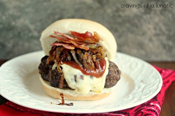 Grilled Burger with Caramelized Onions, Mozzarella and Bacon on a white plate