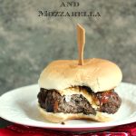 Grilled Burger with Caramelized Onions, Mozzarella and Bacon served on a white plate on a red bandana