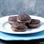 Chocolate Fudge Brownie Sandwich Cookies stacked on blue and white plates.