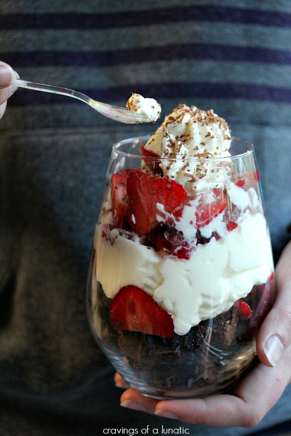 Strawberry Brownie Parfaits served in wine glasses with colourful tiny spoons.