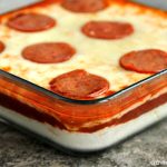 Pizza dip served in a clear square dish.