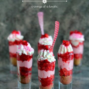 Strawberry Shortcake No Bake Mini Cheesecakes served layered in tall shot glasses with brightly colored spoons