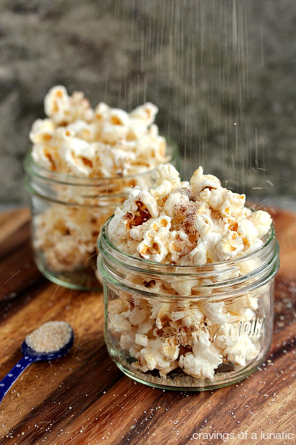 Cinnamon sugar popcorn served in small wide mouth mason jars.