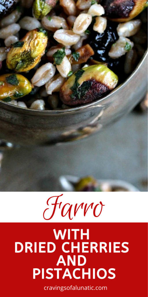Farro with Pistachios and Dried Cherries served in a silver bowl on a dark counter.