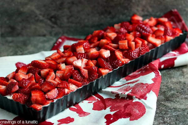 No Bake Strawberry Cheesecake Tart in a long cake pan on a red and white napkin.