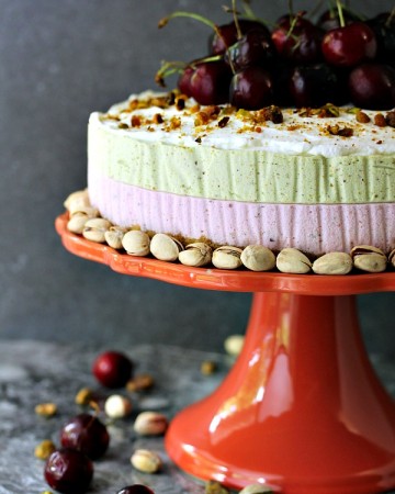 No Bake Cherry and Pistachio Cheesecake with Animal Cracker Crust served on a cake stand