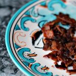 Bacon Bits on a multi coloured plate on a grey counter