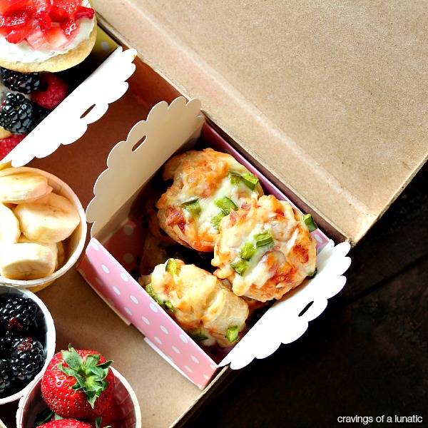 mini pizzas in a small lunch package with fresh fruit nearby