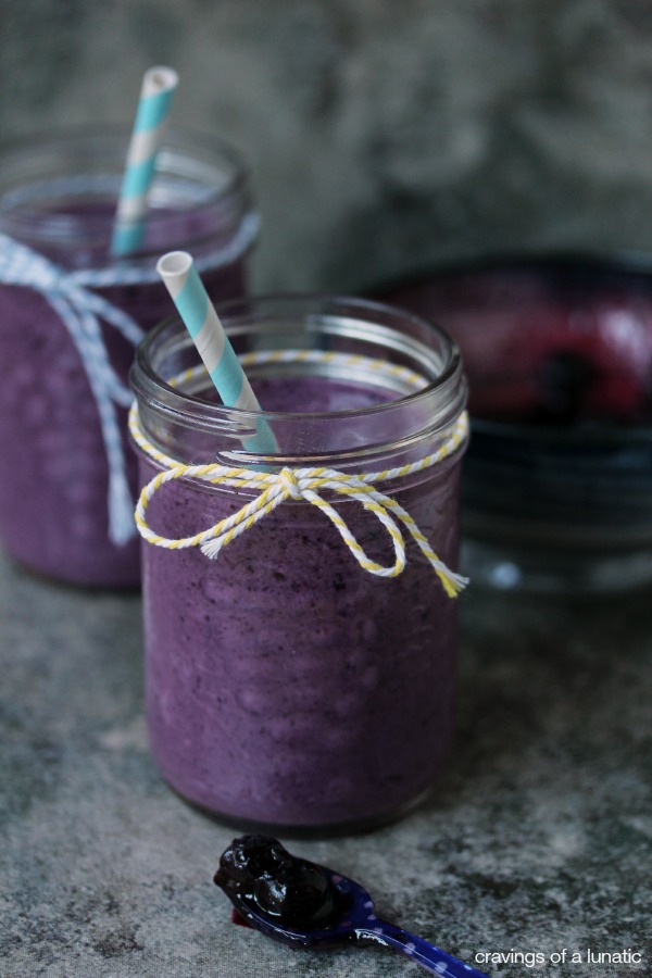 Roasted Blueberry Milkshakes served in mason jars with twine tied around the tops, and blue striped straws inside