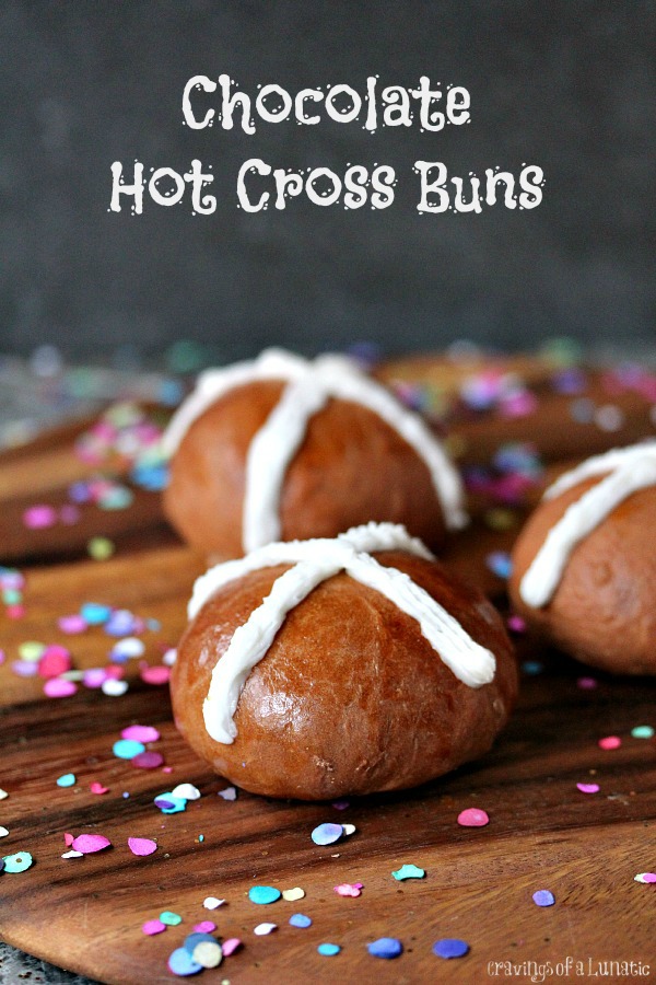 Chocolate Hot Cross Buns on a wood board with confetti all around.