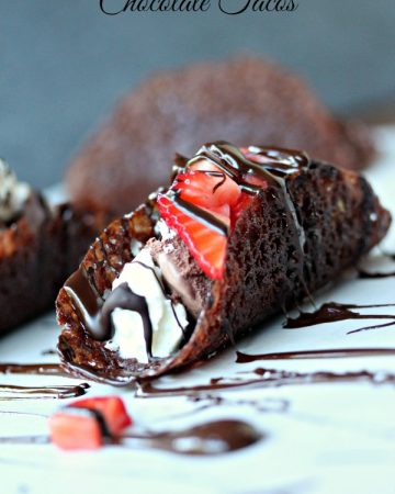 Chocolate tacos filled with ice cream, whipped cream, strawberries and chocolate sauce.