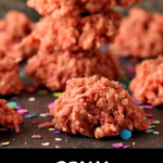 Pink Coconut Cookies on a dark counter with paper confetti sprinkled around.