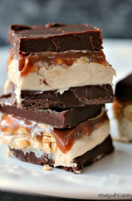 Snickers Cheesecake Bars layered with chocolate, cheesecake, caramel, peanuts and MORE chocolate!
