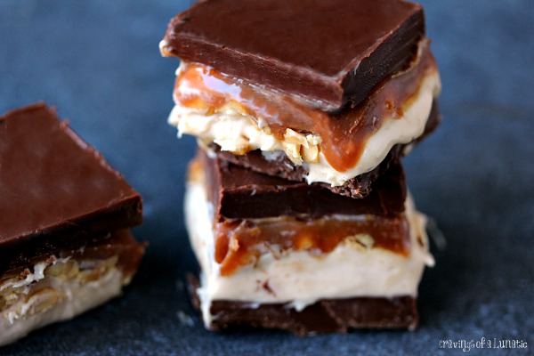 Homemade Snickers Cheesecake Bars layered with chocolate, cheesecake, caramel and peanuts.