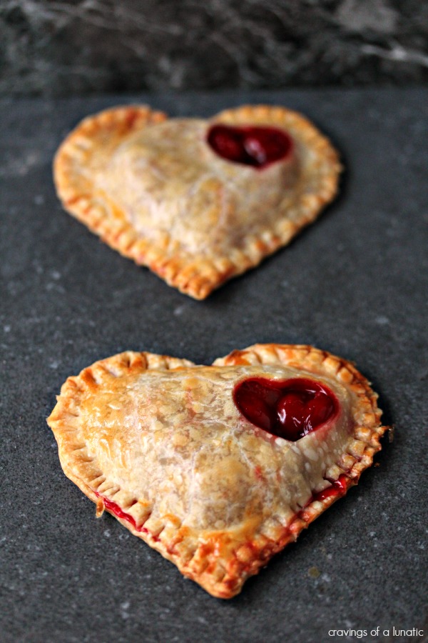 Toasted Coconut and Cherry Hand Pies on a dark counter.