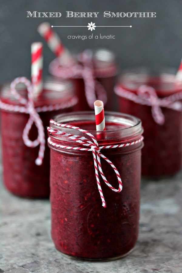 Mixed Berry Smoothie served in mason jars with twine tied on the rims and red and white straws in each glass.