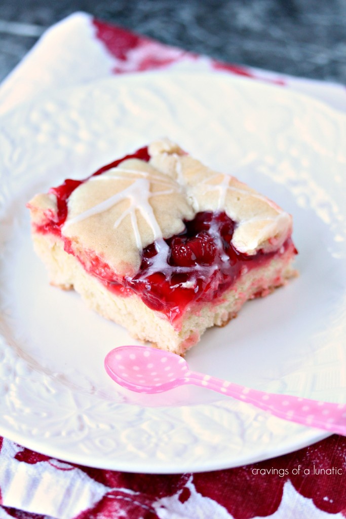 Cherry Bars aka Cherry Kuchen on a white plate with a pink and white spoon resting on the plate