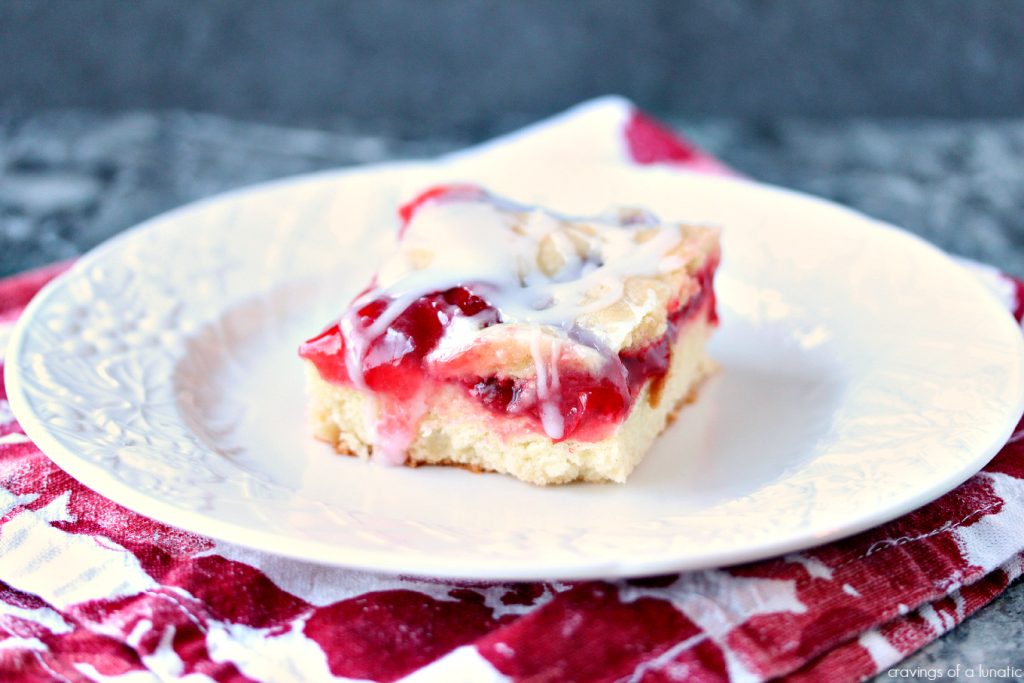 Cherry Bars aka Cherry Kuchen on a white plate that is sitting on a red and white napkin.