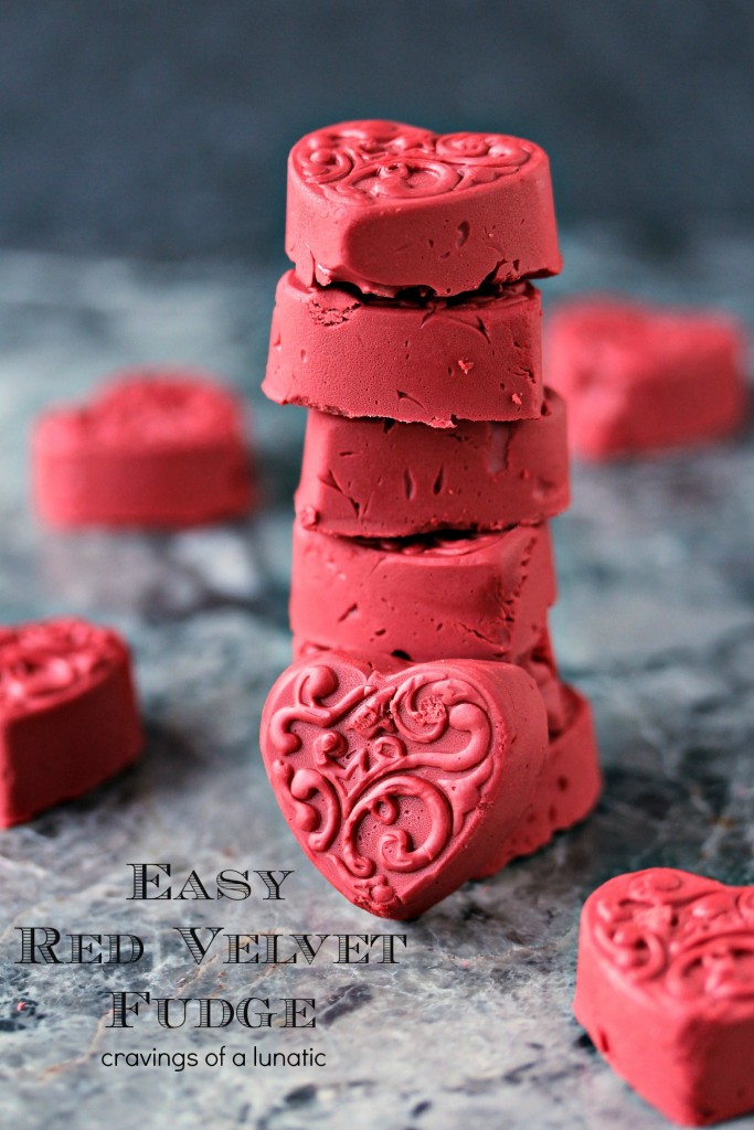 Red Velvet Fudge shaped like hearts and stacked up on a grey counter.
