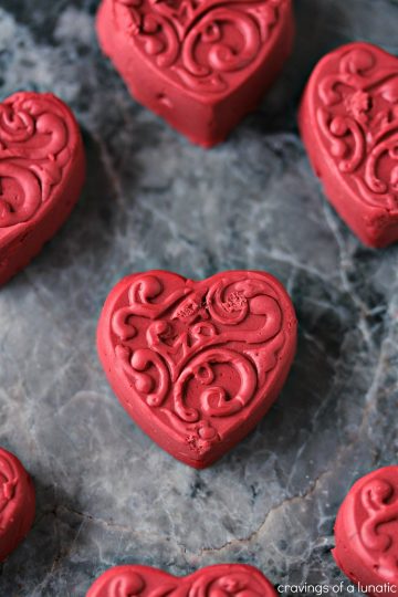 Red Velvet Fudge shaped like hearts and cooling on a grey counter.