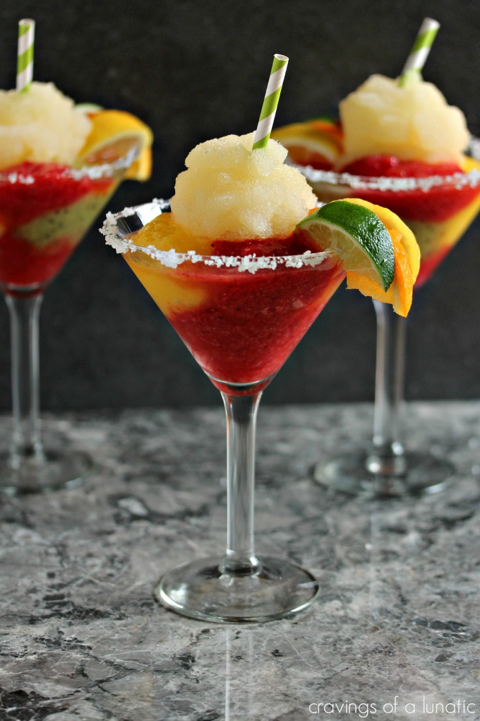 three glasses of frozen margarita made with Tequila, kiwi, strawberry and mango ices and served with a shot of Cactus Juice Schnapps