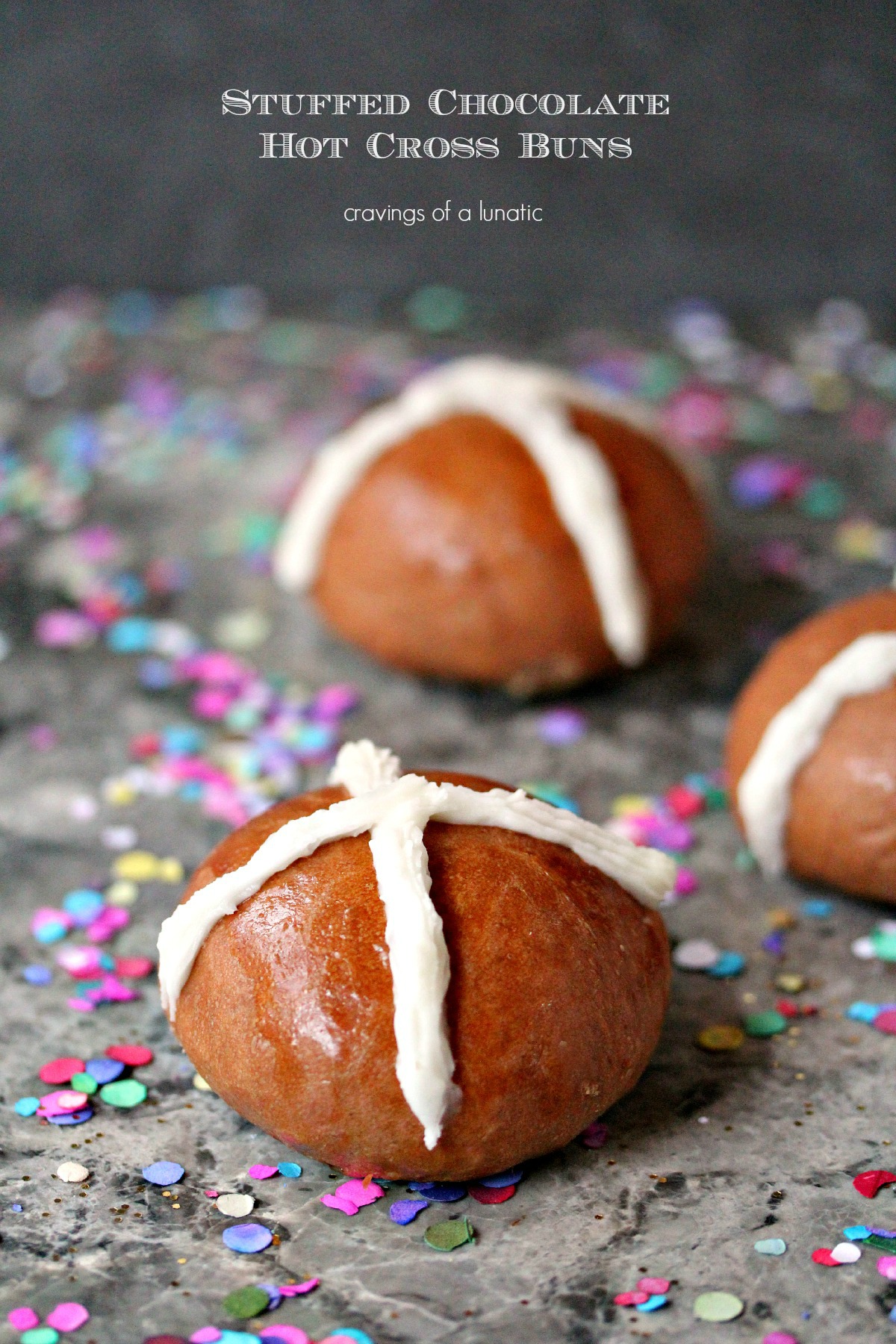 Stuffed Chocolate Hot Cross Buns on grey counter with confetti scattered around