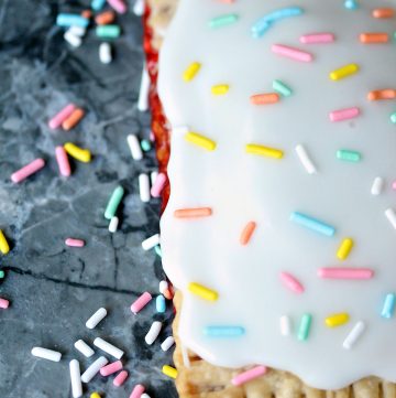 Easy Semi-Homemade Strawberry Pop Tarts on counter with lots of colourful sprinkles scattered around