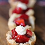 Strawberry Filled Mini Puff Pastries on a wood board