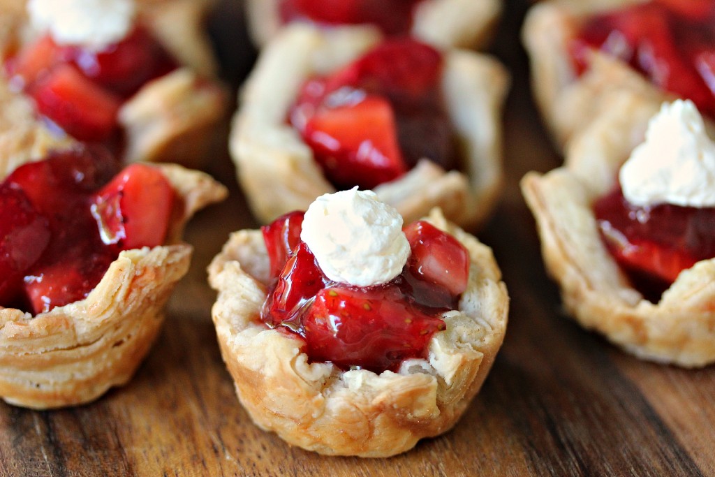 Strawberry Filled Mini Puff Pastries served on a wooden board