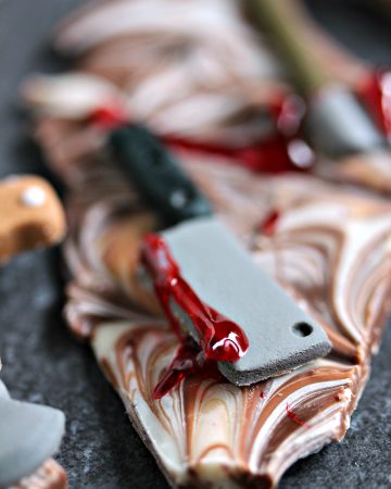 Chocolate Weapons Bark pieces on a dark surface.