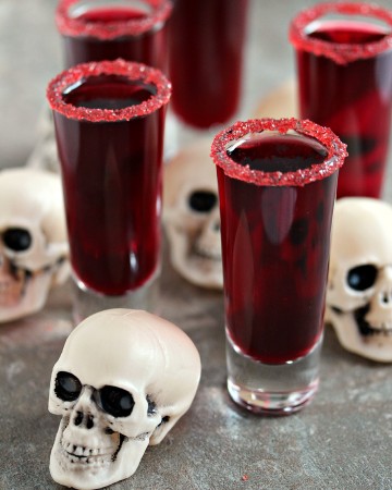 walker blood sangria served in shot glasses, tiny plastic skulls are scattered around them
