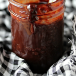 Nutella ganache is a mason jar on a red and white checkered napkin.