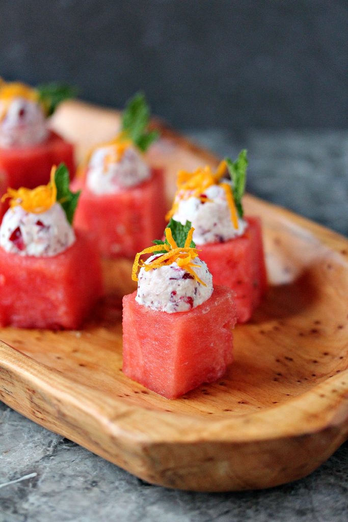 Watermelon Cups with Cranberry Mascarpone served on a wood tray.