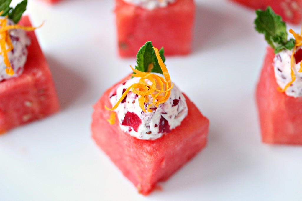 Watermelon Cups with Cranberry Mascarpone served on a white plate. Cups are garnished with lemon zest and mint.