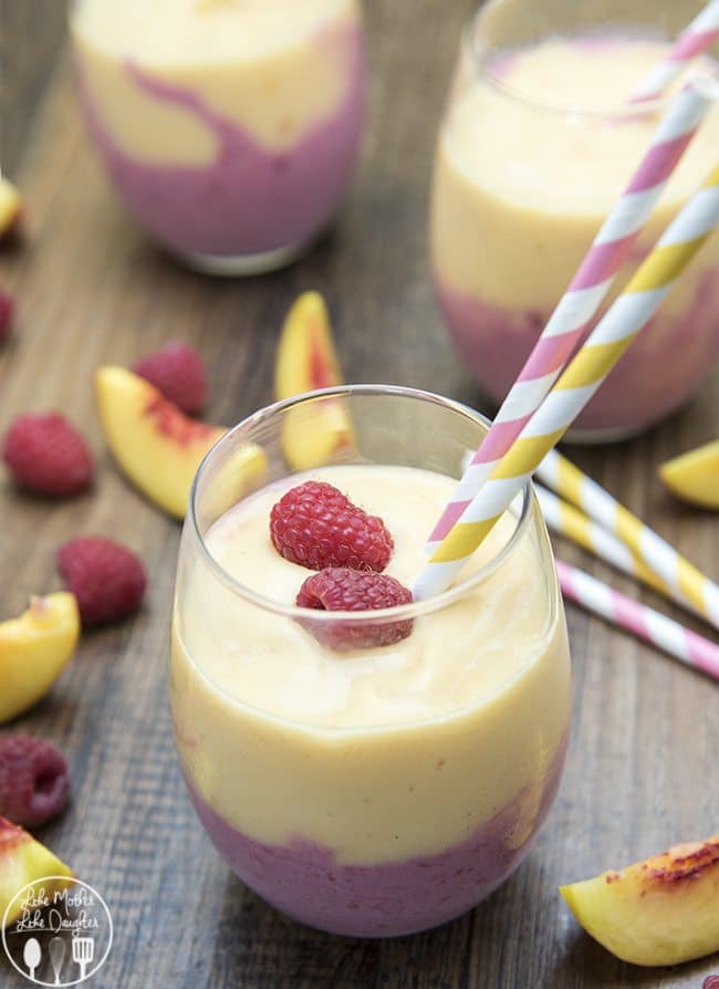raspberry peach smoothie served in glasses with straws
