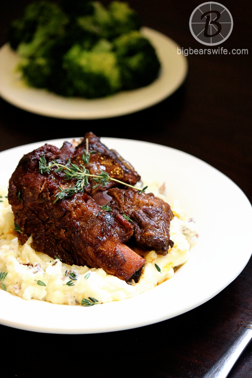 Slow Cooker Braised Short Ribs – Big Bears Wife image of finished recipe in a white serving dish on a dark surface. 