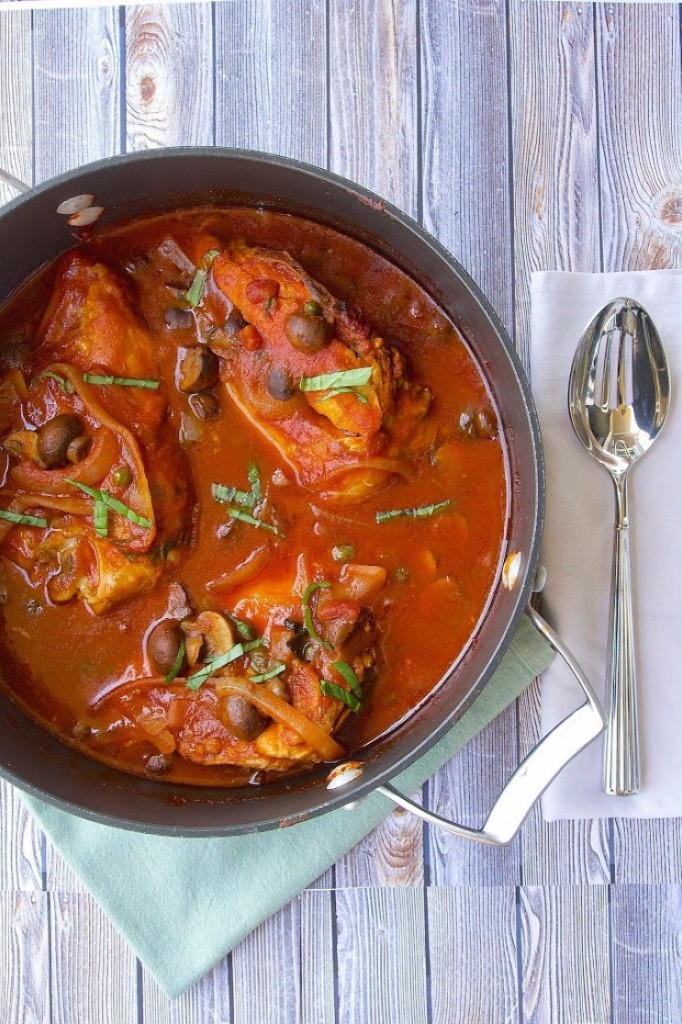 Slow Cooker Chicken Cacciatore – Culinary Ginger image of cacciatore in a dark bowl on a blue napkin on a wood board