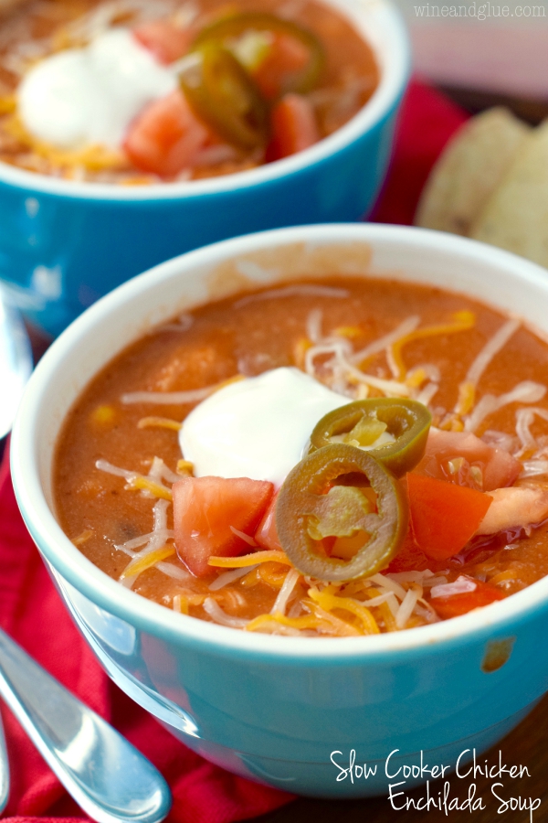 Slow Cooker Chicken Enchilada Soup from Wine & Glue in blue bowls on a red napkin.