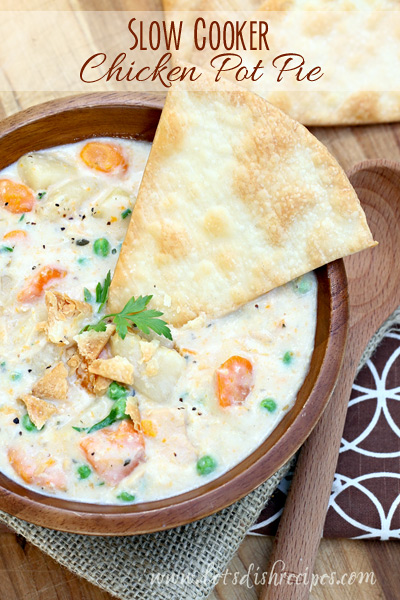 Slow Cooker Chicken Pot Pie – Let’s Dish image of pot pie in a dark bowl on a wood table. 